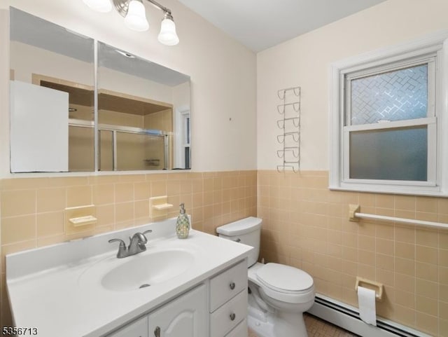 bathroom featuring a stall shower, toilet, tile walls, vanity, and a baseboard heating unit
