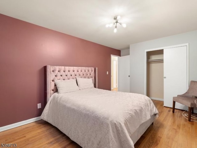 bedroom featuring light wood-type flooring, a closet, and baseboards