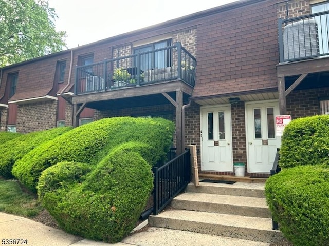 703 Nottingham Way, Raritan Twp, NJ 08822 - back of house featuring a balcony, brick siding, and a shingled roof