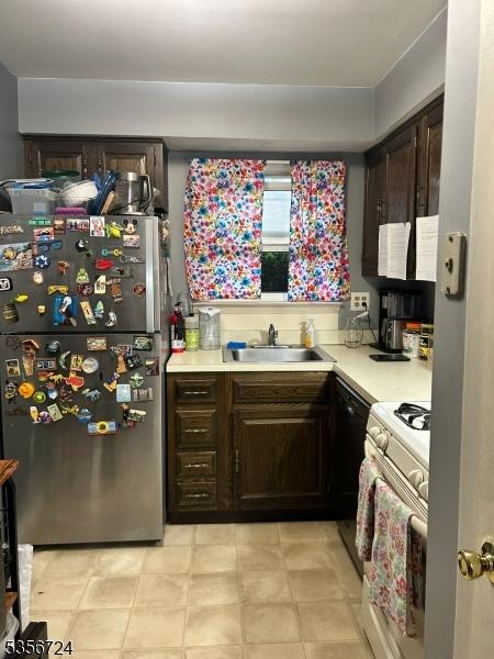 703 Nottingham Way, Raritan Twp, NJ 08822 - kitchen featuring freestanding refrigerator, a sink, white gas range oven, light countertops, and dark brown cabinetry