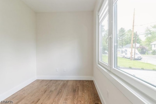 spare room featuring light wood-style floors and baseboards