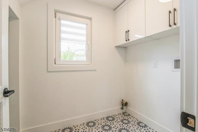 laundry room with cabinet space and baseboards