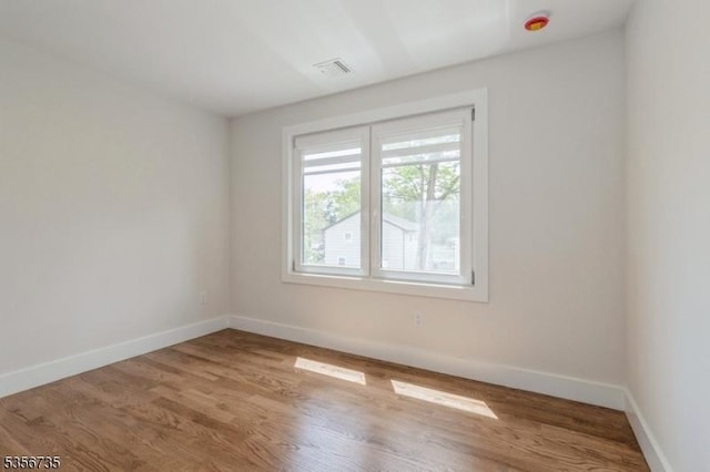 empty room featuring baseboards and wood finished floors