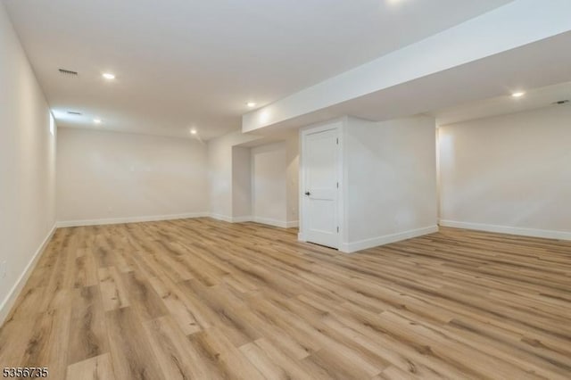 finished below grade area featuring light wood-style floors, baseboards, and recessed lighting