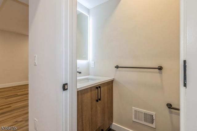 bathroom featuring vanity, baseboards, and wood finished floors