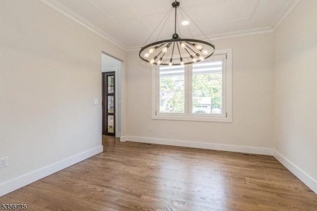unfurnished dining area featuring a chandelier, wood finished floors, crown molding, and baseboards
