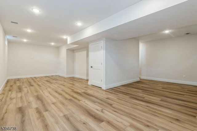 finished basement featuring baseboards, light wood finished floors, and recessed lighting