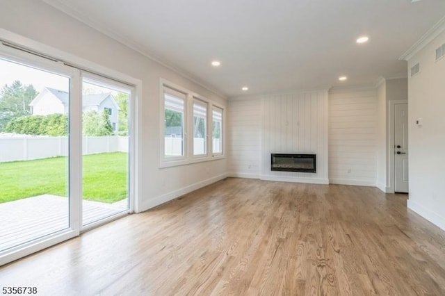 unfurnished living room with crown molding, baseboards, light wood finished floors, a large fireplace, and recessed lighting