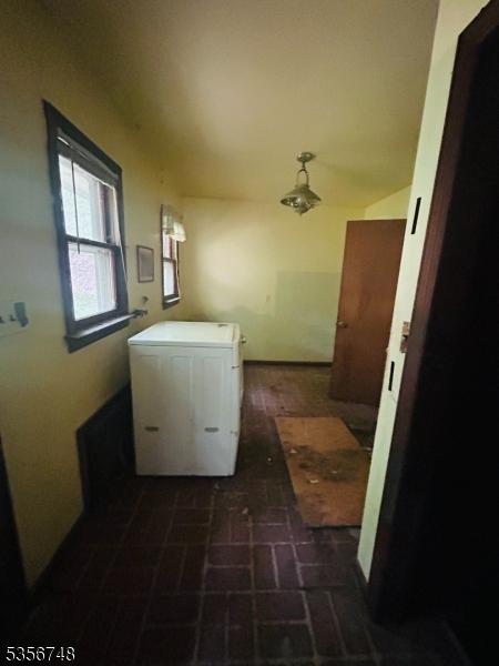 clothes washing area featuring brick patterned flooring