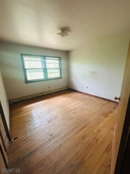 spare room featuring wood finished floors and baseboards