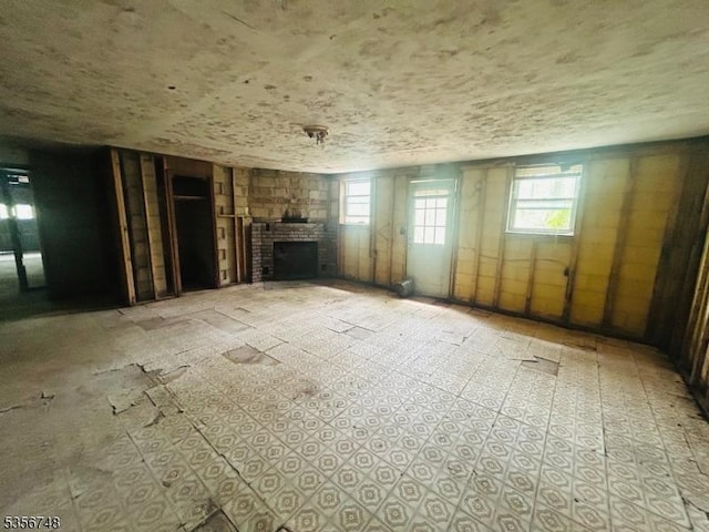unfurnished living room with a fireplace and plenty of natural light