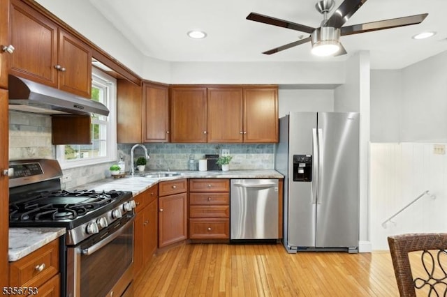 9 Copperfield Rd, Scotch Plains Twp, NJ 07076 - kitchen with stainless steel appliances, under cabinet range hood, a sink, brown cabinets, and light stone countertops