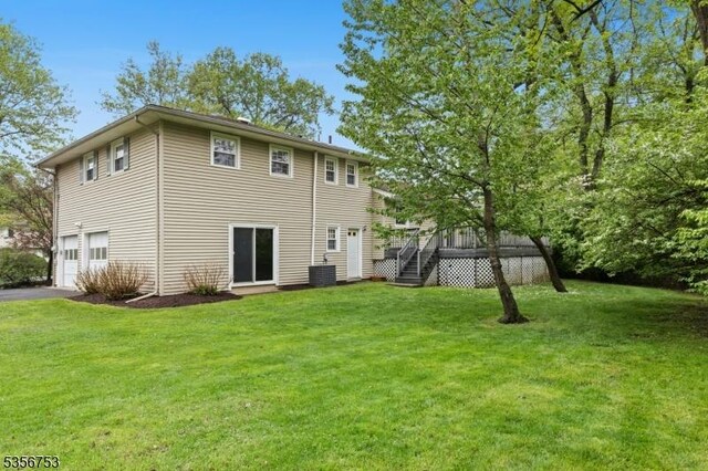9 Copperfield Rd, Scotch Plains Twp, NJ 07076 - back of property featuring an attached garage, stairs, asphalt driveway, a deck, and a lawn
