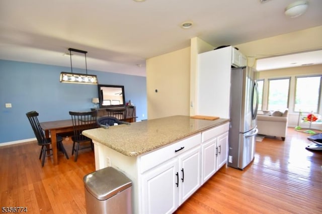 1 Wimbledon Dr Unit 3, Vernon Twp, NJ 07462 - kitchen with freestanding refrigerator, light wood-style flooring, light stone countertops, white cabinetry, and hanging light fixtures