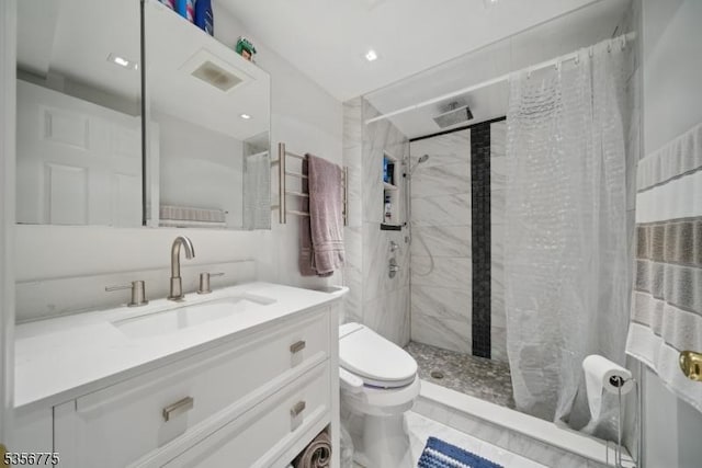 bathroom featuring toilet, a stall shower, and vanity