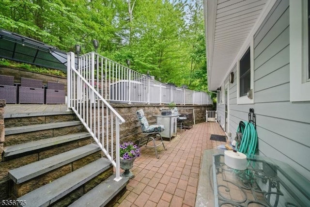 view of patio with stairs and fence