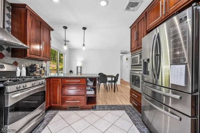 kitchen featuring appliances with stainless steel finishes, wall chimney exhaust hood, a peninsula, decorative backsplash, and recessed lighting