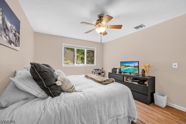 bedroom featuring light wood finished floors, baseboards, and ceiling fan