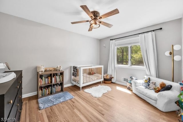 bedroom with wood finished floors, baseboards, and a ceiling fan
