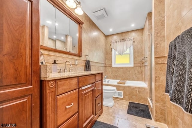bathroom with tile walls, tiled shower, tile patterned floors, tiled bath, and vanity