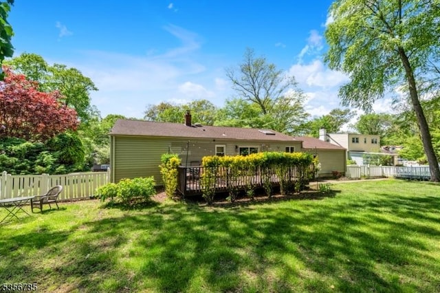 back of property featuring a wooden deck and a chimney
