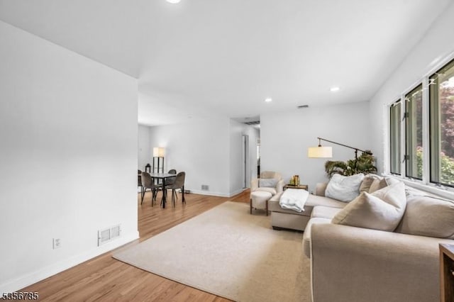 living area featuring light wood-style flooring, recessed lighting, and baseboards