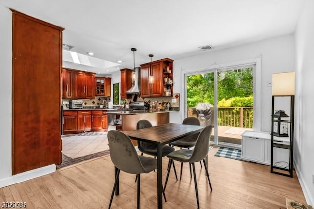 dining room with light wood finished floors and recessed lighting