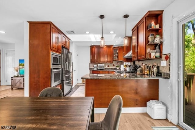 kitchen with appliances with stainless steel finishes, a peninsula, open shelves, dark stone countertops, and light wood-style floors