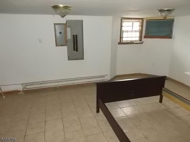 spare room with electric panel, light tile patterned floors, and a baseboard heating unit