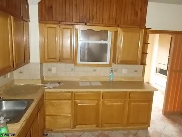 kitchen featuring backsplash, a sink, and light countertops