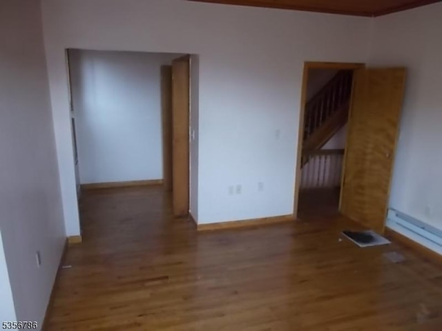 unfurnished room with wood finished floors and baseboards