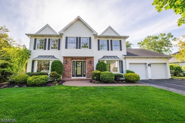 view of front of home featuring a garage, asphalt driveway, brick siding, and a front lawn