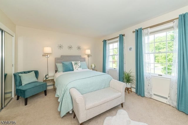bedroom featuring light carpet and a baseboard radiator