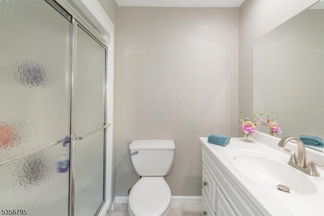 bathroom featuring a stall shower, vanity, tile patterned floors, toilet, and baseboards