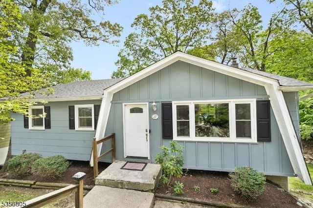 ranch-style home featuring board and batten siding and a shingled roof