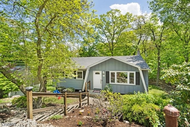 ranch-style house with board and batten siding and roof with shingles