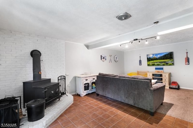 living area featuring a wood stove, a textured ceiling, baseboards, and tile patterned floors