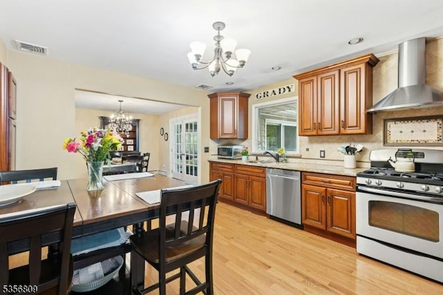 96 Belmont Ave, Cranford Twp, NJ 07016 - kitchen featuring appliances with stainless steel finishes, wall chimney range hood, a chandelier, brown cabinetry, and recessed lighting