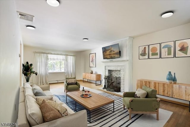 29 Dogwood Trl, Randolph Twp, NJ 07869 - living room with a baseboard heating unit, wood finished floors, and a brick fireplace