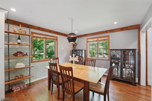 dining area with wood finished floors, brick wall, and recessed lighting