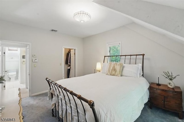 bedroom featuring dark colored carpet, a spacious closet, baseboards, and vaulted ceiling
