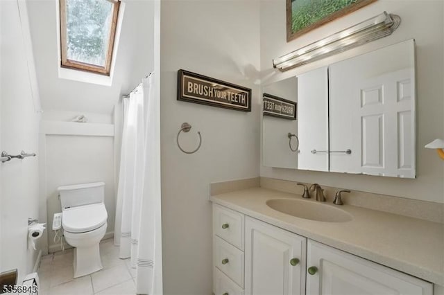 full bathroom featuring tile patterned floors, a skylight, toilet, and vanity