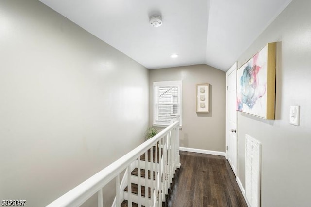 hall featuring dark wood finished floors, vaulted ceiling, baseboards, an upstairs landing, and recessed lighting