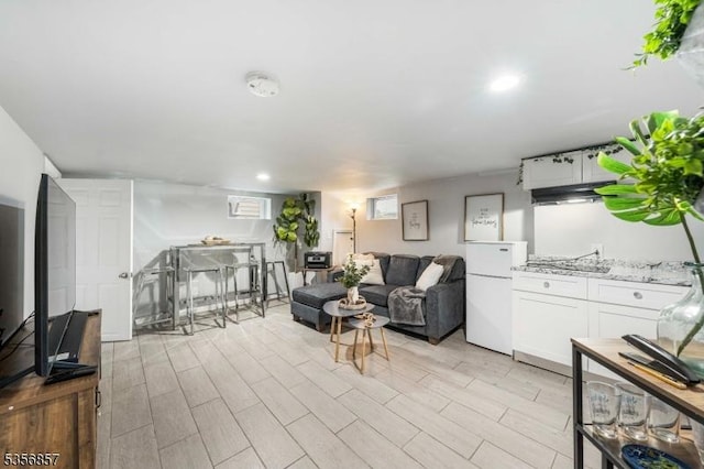 living area with light wood-style floors and recessed lighting