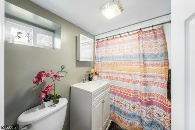 full bath featuring toilet, vanity, and curtained shower