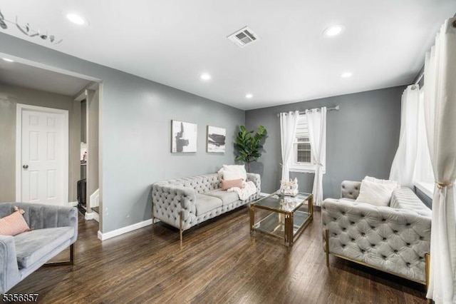 living area with baseboards, wood finished floors, and recessed lighting