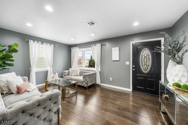 living area featuring baseboards, dark wood-type flooring, and recessed lighting