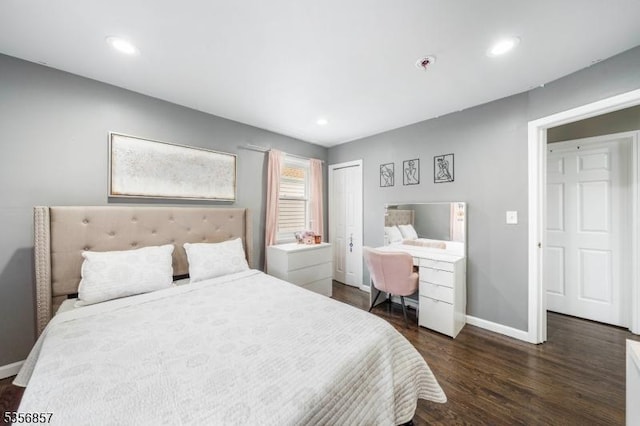 bedroom with baseboards, dark wood-type flooring, recessed lighting, an office area, and a closet