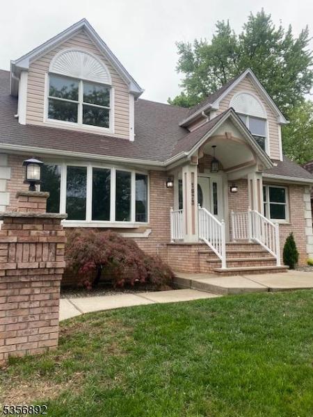 1673 Raritan Rd, Clark Twp, NJ 07066 - view of front of home featuring brick siding, a front yard, and roof with shingles