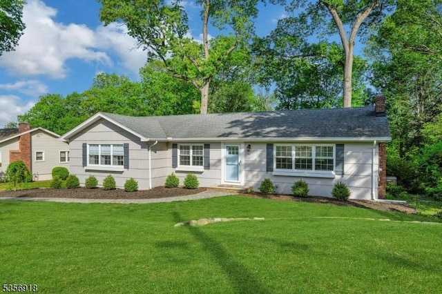 ranch-style home with a chimney and a front lawn